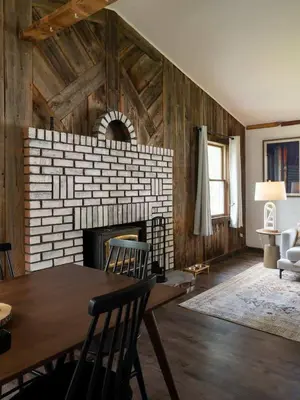 a living room with a fireplace and a table and chairs at Hunter Mountain View Cabin in Lanesville