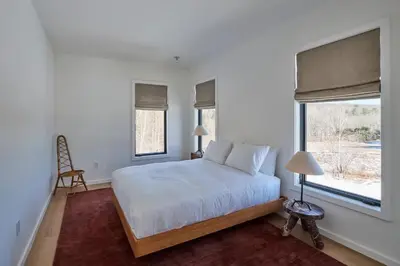 a bedroom with a white bed and a window at Modern Mountain Retreat with Hot Tub in Fleischmanns