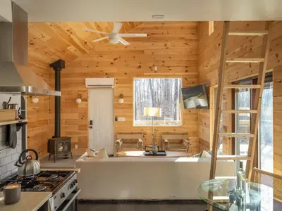 a kitchen with a stove and a tub in a room at Modern Rustic Tiny Home in the Catskills in Roscoe