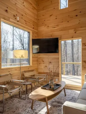 a living room with wooden walls and a table and chairs at Modern Rustic Tiny Home in the Catskills in Roscoe