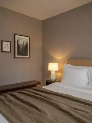 a bedroom with a bed with a lamp and a picture at Chic Cabin with Hot Tub and Fire Pit in Roscoe