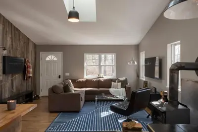 a living room with a couch and a blue rug at Chic Cabin with Hot Tub and Fire Pit in Roscoe