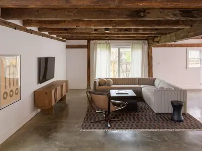 a living room with a couch and a tv at Chic Barn House with Pool in Germantown