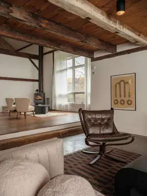 a leather chair in a living room with a fireplace at Chic Barn House with Pool in Germantown