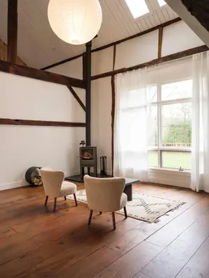 a living room with two chairs and a table and a window at Chic Barn House with Pool in Germantown
