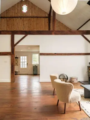 an open living room with wooden ceilings and chairs at Chic Barn House with Pool in Germantown