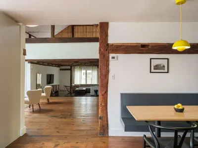 a dining room and living room with wooden beams at Chic Barn House with Pool in Germantown