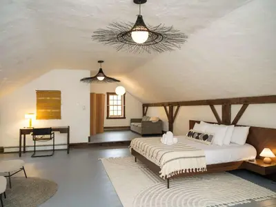 a bedroom with a large bed and a living room at Chic Barn House with Pool in Germantown