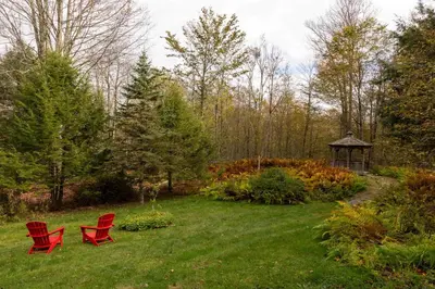 two red chairs in a yard with a gazebo at Private Chalet with Fire Pit Deck and Large Yard in Roscoe