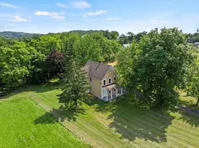 an overhead view of a house in a field with trees at Hudson Restored Farmhouse with Fire Pit in Hudson