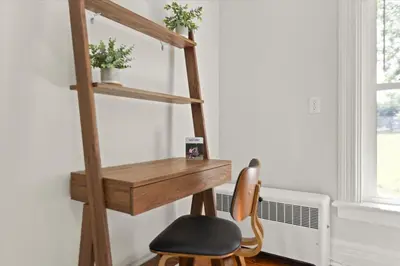 a wooden desk with a chair in a room at Hudson Restored Farmhouse with Fire Pit in Hudson