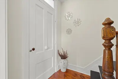 a hallway with a door and a vase with flowers on the wall at Hudson Restored Farmhouse with Fire Pit in Hudson