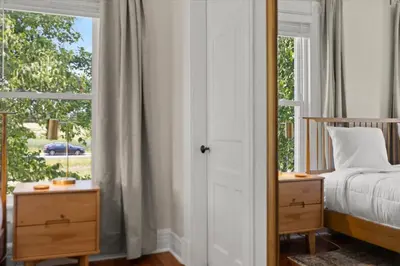 a bedroom with a bed and a large window at Hudson Restored Farmhouse with Fire Pit in Hudson