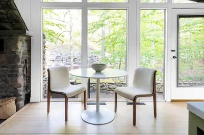 a table and two chairs in a room with windows at Private Cabin by River with Fireplace in Phoenicia