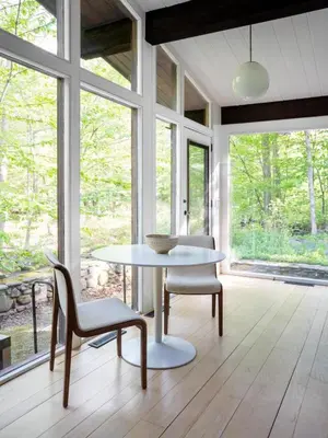 a table and chairs in a room with windows at Private Cabin by River with Fireplace in Phoenicia