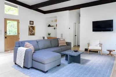 a living room with a blue couch and a table at Private Cabin by River with Fireplace in Phoenicia