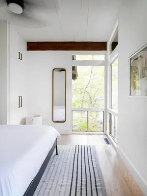 a bedroom with a bed and a large window at Private Cabin by River with Fireplace in Phoenicia