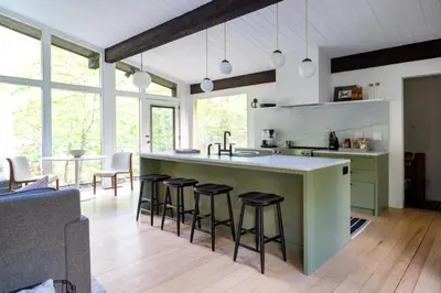 a kitchen with a island with bar stools at Private Cabin by River with Fireplace in Phoenicia