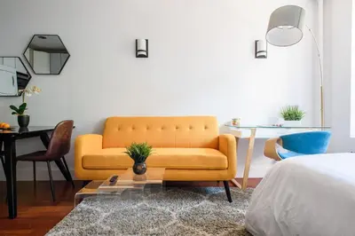 a living room with a yellow couch and a table at 24-10 Studio in Prime Gramercy WD in Unit in New York