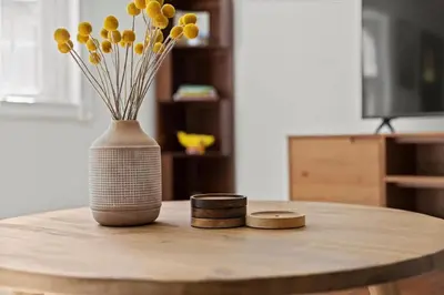 a table with a vase with yellow flowers on it at Cozy Home with Game Room and Fire Pit in New Paltz