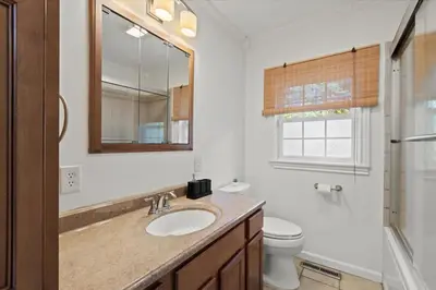 a bathroom with a sink and a toilet and a mirror at Cozy Home with Game Room and Fire Pit in New Paltz