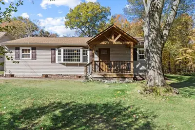 a house with a porch and a tree at Cozy Home with Game Room and Fire Pit in New Paltz