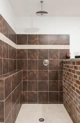 a bathroom with a shower with brown tiles at Chic Farmhouse Woodstock Saugerties Skiing HITS in Saugerties