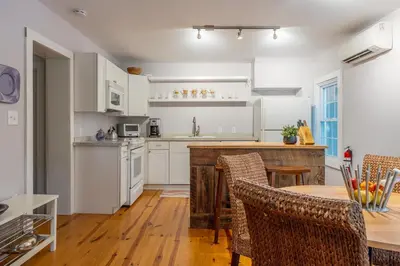 a kitchen with white cabinets and a table with chairs at Chic Farmhouse Woodstock Saugerties Skiing HITS in Saugerties