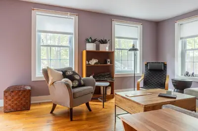 a living room with a chair and a table at Chic Farmhouse Woodstock Saugerties Skiing HITS in Saugerties