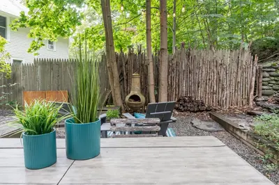 a backyard with a table and two potted plants at Chic Farmhouse Woodstock Saugerties Skiing HITS in Saugerties