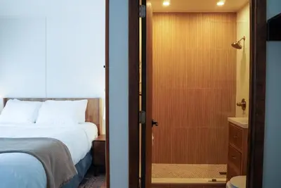 a bedroom with a bed and a bathroom with a shower at The Perch Hotel in East Windham