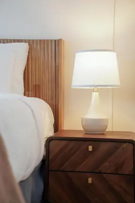 a lamp on a night stand next to a bed at The Perch Hotel in East Windham