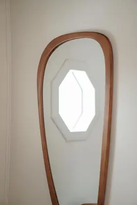 a mirror with a wooden frame on a wall at The Perch Hotel in East Windham