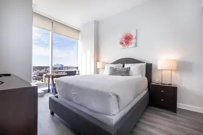a bedroom with a large bed and a large window at Luxury 2 BR Apt with Gym in Stamford
