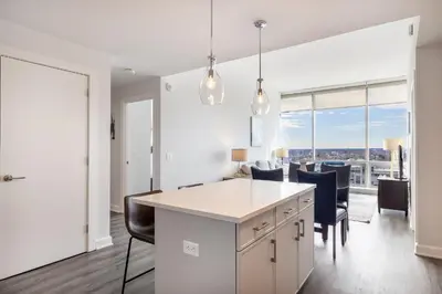 an open kitchen with a white island and chairs at Luxury 2 BR Apt with Gym in Stamford