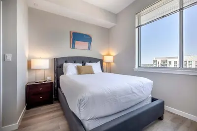 a bedroom with a large bed and a window at Spacious Harbor Apt with Balcony in South End