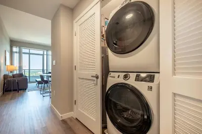 a washer and dryer in a living room at Spacious Harbor Apt with Balcony in South End