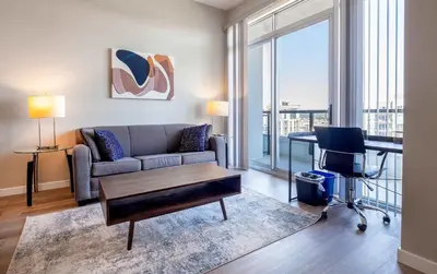 a living room with a couch and a table at Spacious Harbor Apt with Balcony in South End