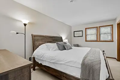 a bedroom with a large bed with white sheets at 3BR Lake Luzerne Retreat with Game Room & Cozy Fire Pit in Lake Luzerne