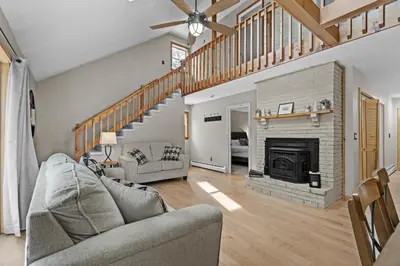 a living room with a couch and a fireplace at 3BR Lake Luzerne Retreat with Game Room & Cozy Fire Pit in Lake Luzerne