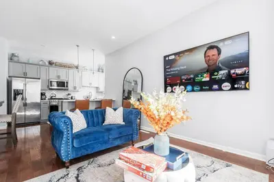 a living room with a blue couch and a tv at Modern 3 Bed Apt Parking W D in Schenectady
