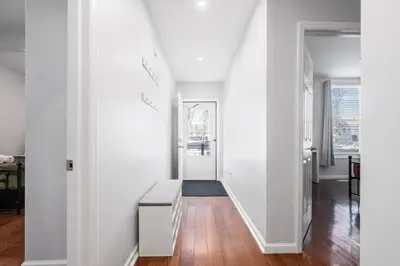 a living room with white walls and a hallway with a table at Modern 3 Bed Apt Parking W D in Schenectady