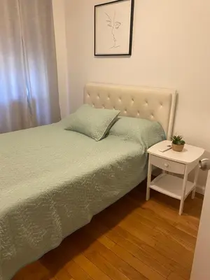 a bedroom with a bed and a nightstand with a table at Prime Murray Hill 2 BR Gem in New York