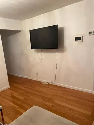 a living room with a flat screen tv on a wall at Prime Murray Hill 2 BR Gem in New York