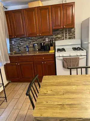 a kitchen with wooden cabinets and a white stove at Prime Murray Hill 2 BR Gem in New York