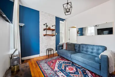 a living room with blue walls and a blue couch at Spacious 2BR on the Upper East Side Steps from Central Park in New York