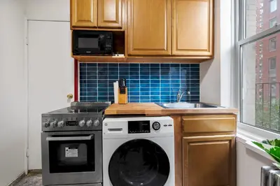 a kitchen with a washing machine and a sink at Spacious 2BR on the Upper East Side Steps from Central Park in New York