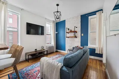 a living room with a couch and a tv at Spacious 2BR on the Upper East Side Steps from Central Park in New York