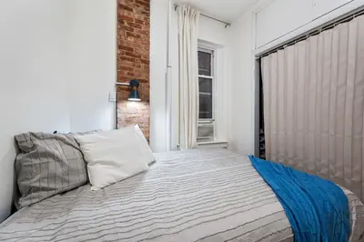 a bedroom with a bed and a window at Spacious 2BR on the Upper East Side Steps from Central Park in New York