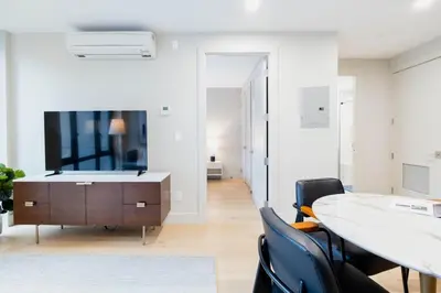a living room with a tv and a table and chairs at 149BK-301 New Construction 1BR Prime BK WD in Brooklyn